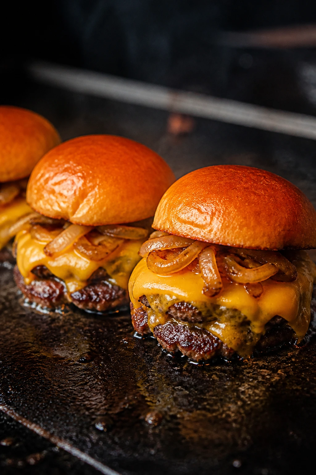 Smash burger sliders with double cheese on cast-iron griddle outdoors