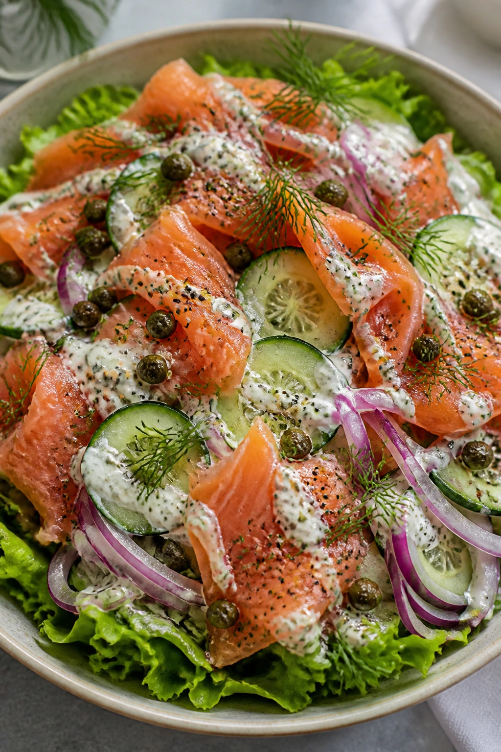 Close-up of Smoked Salmon Bagel Salad with greens cucumber dill