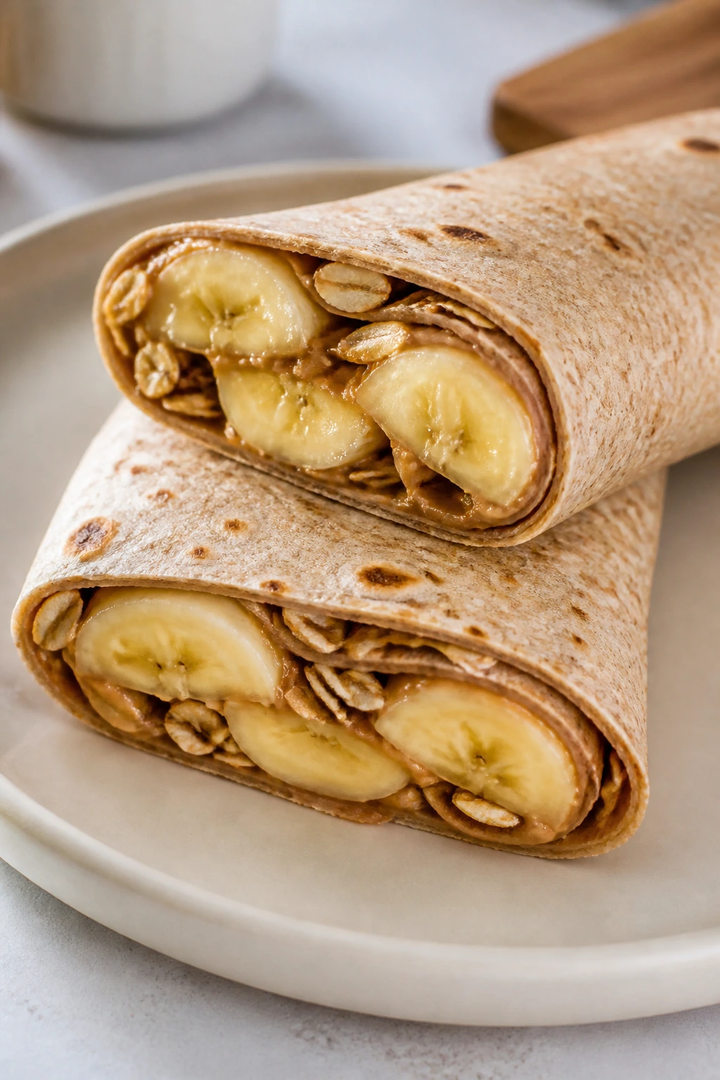 Close-up of a sunflower butter banana oat wrap sliced to reveal banana and oats.