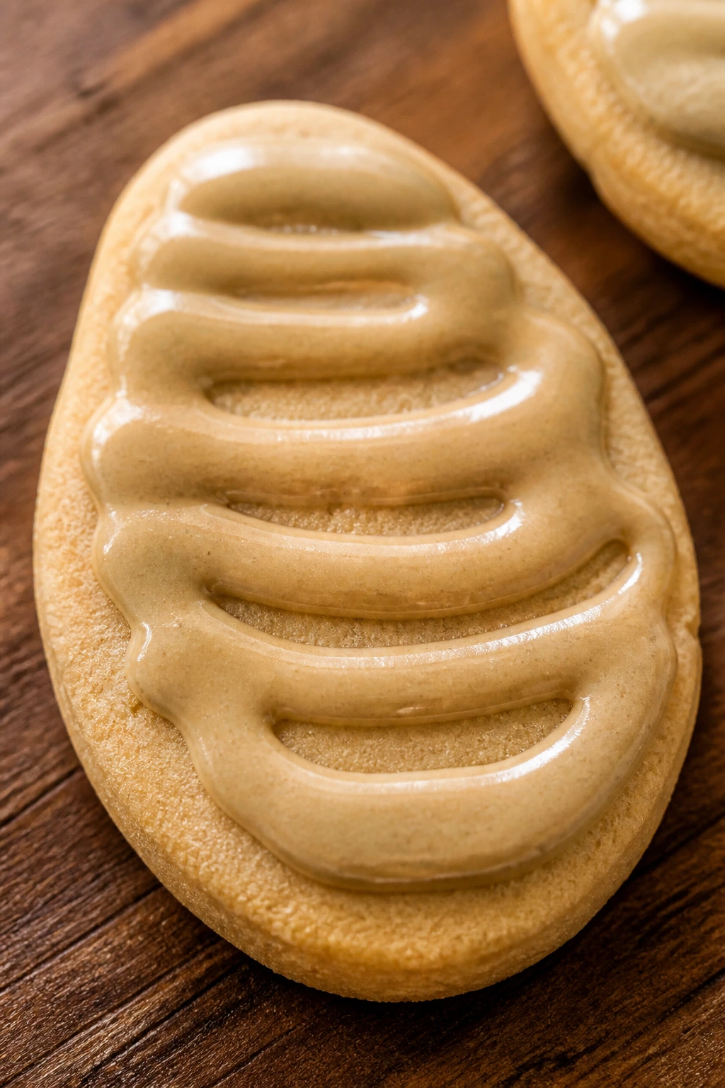 Close-up of sunflower butter Easter egg cookie with pale swirl topping