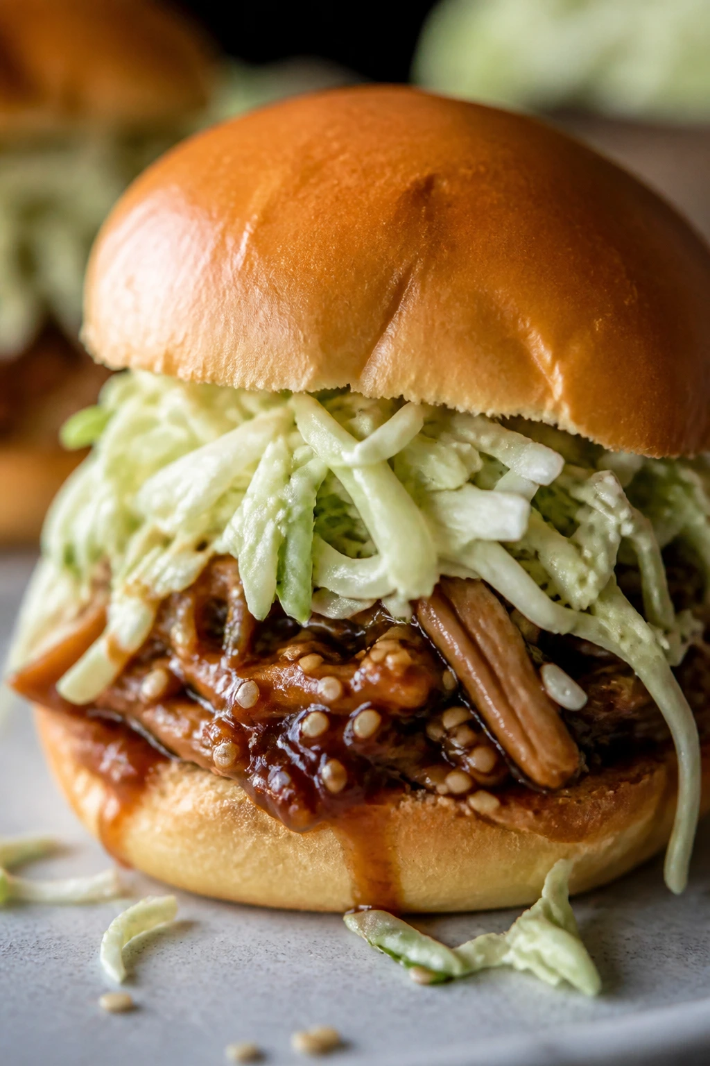 Close-up teriyaki chicken slider with crisp cabbage on a soft bun