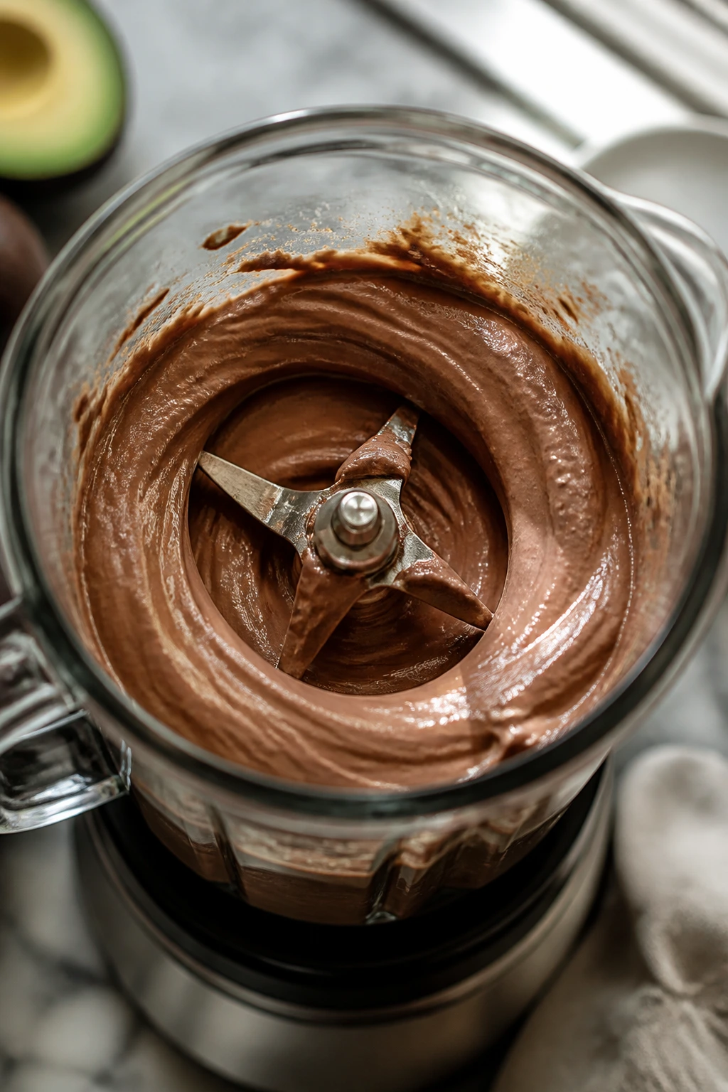 Blender jar filled with pudding, blades visible, on kitchen counter.