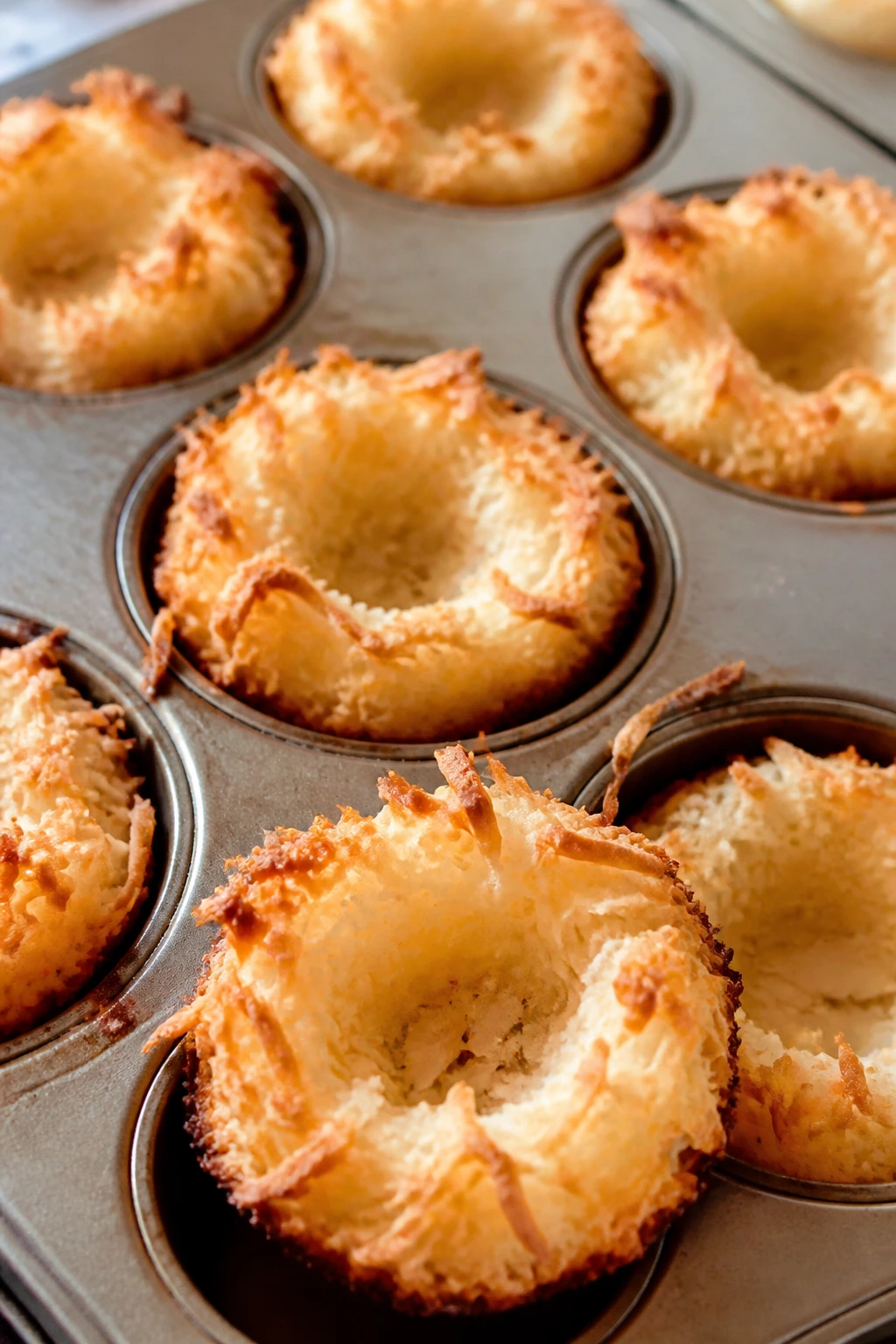 Close-up of toasted coconut macaroon nests in muffin tin wells