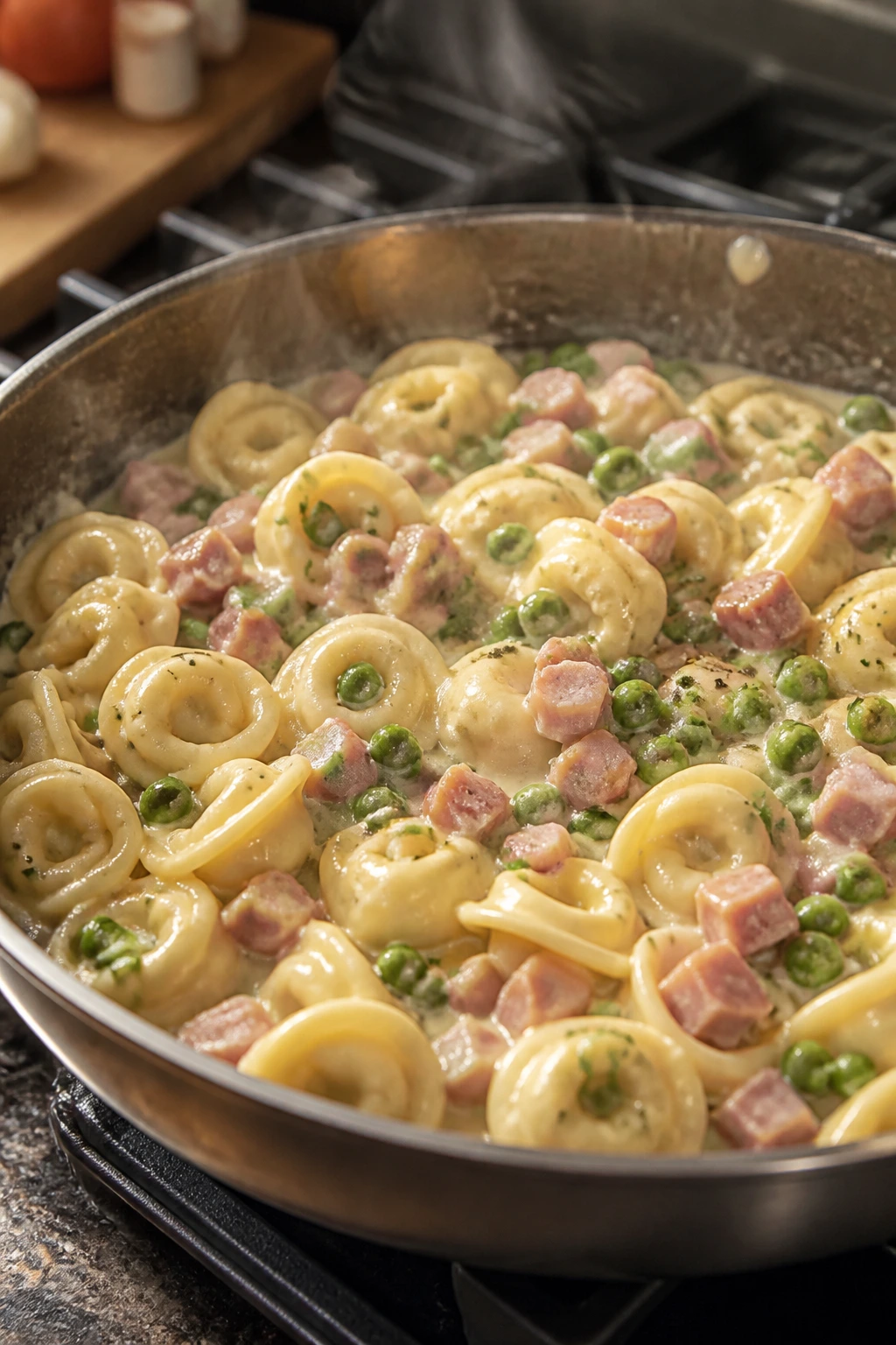 Creamy tortellini with peas and ham in a skillet