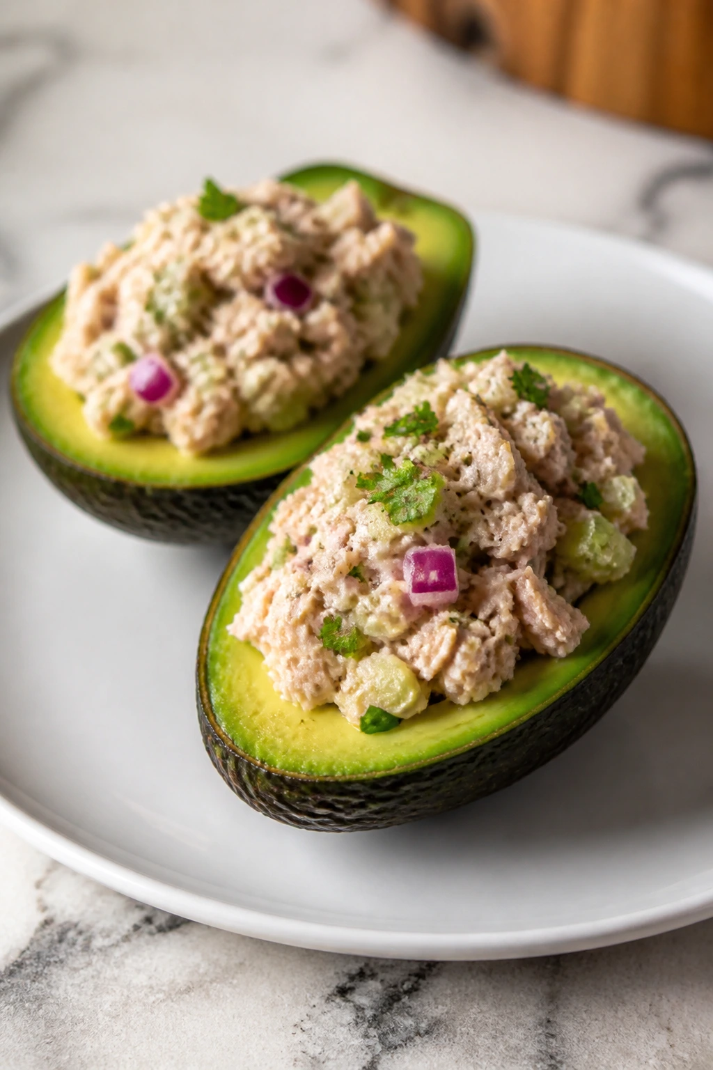 Two avocado halves stuffed with tuna salad