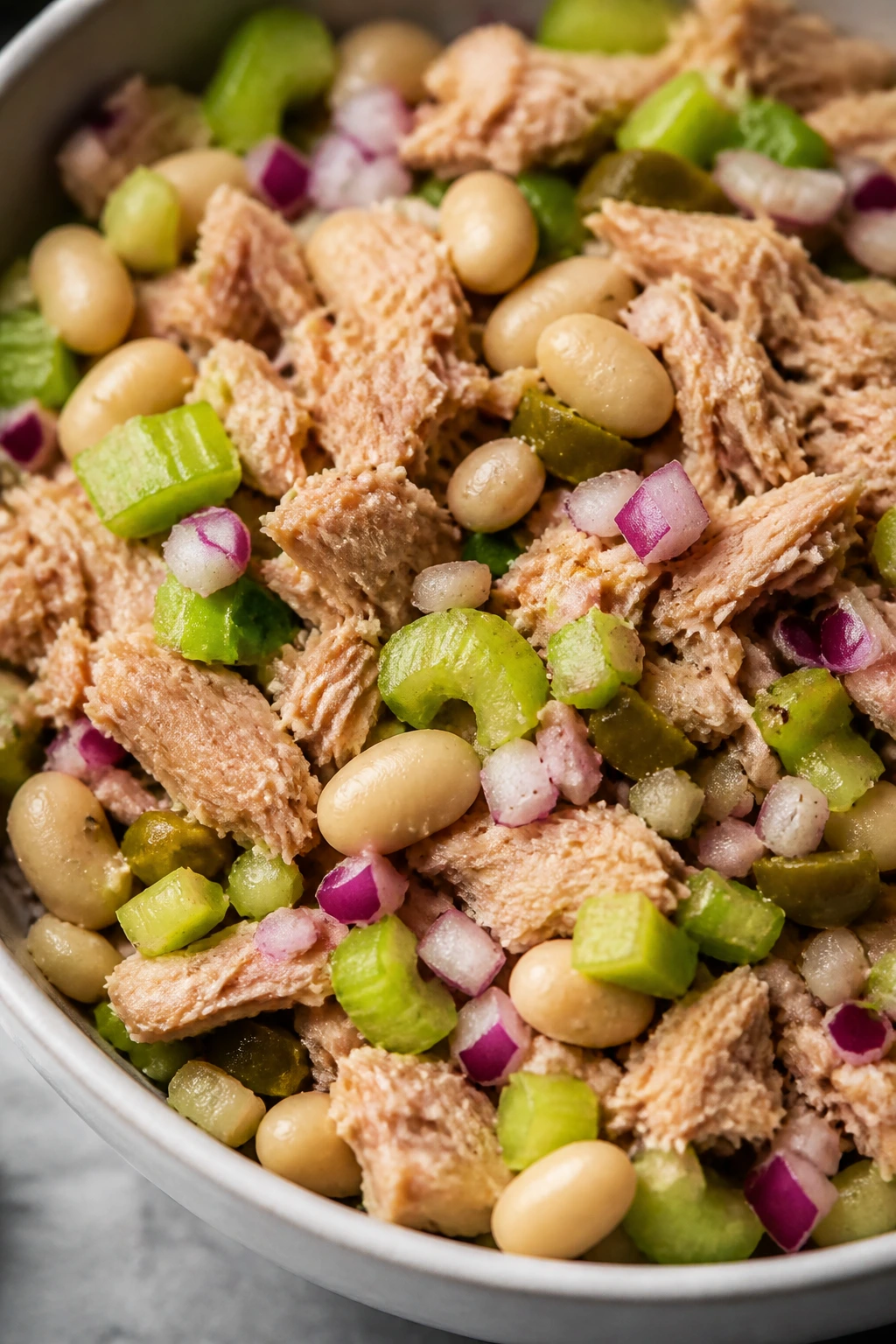 Close-up of tuna and cannellini beans with celery and red onion in a bowl