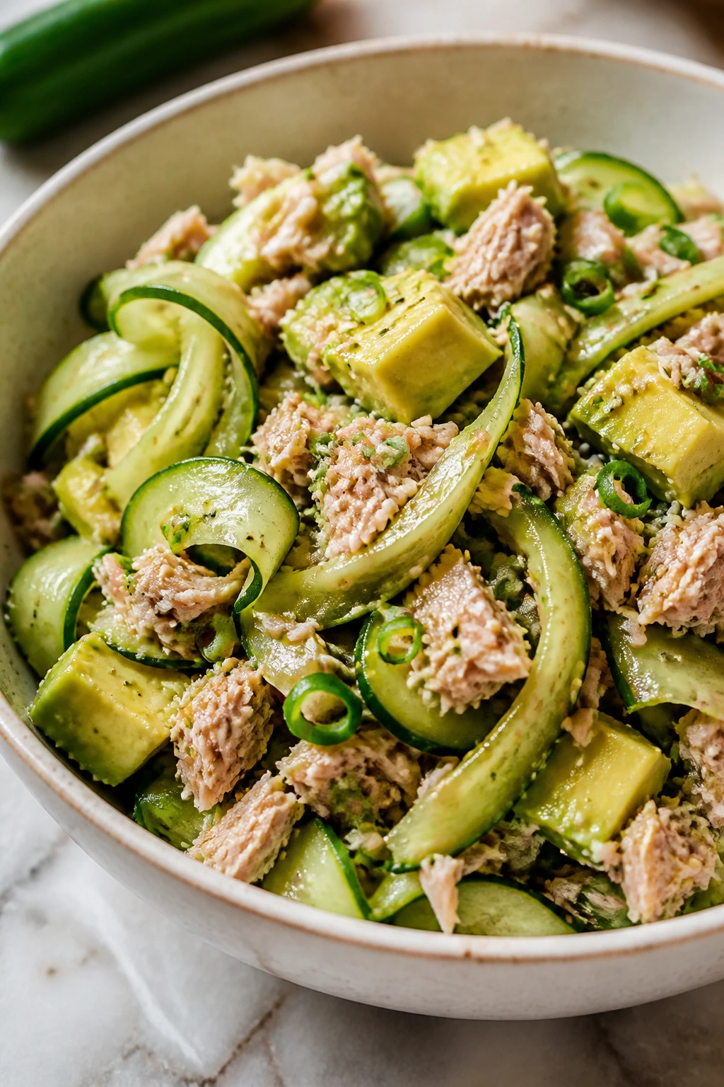 Close-up of Sesame-Cucumber Tuna Salad with Rice Vinegar featuring tuna, cucumber, avocado, sesame seeds.