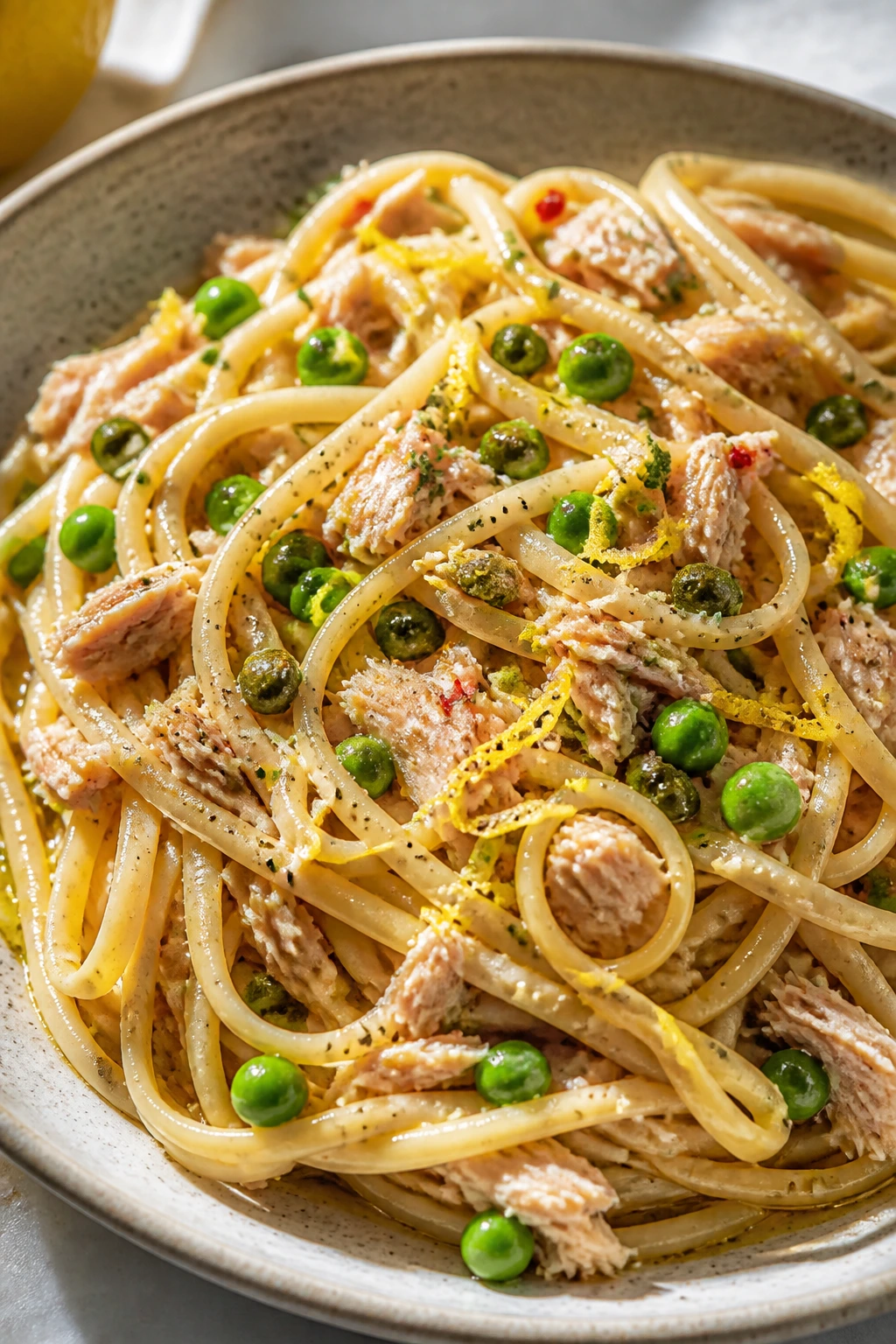 Plate of tuna pasta with lemon zest, capers, and peas.
