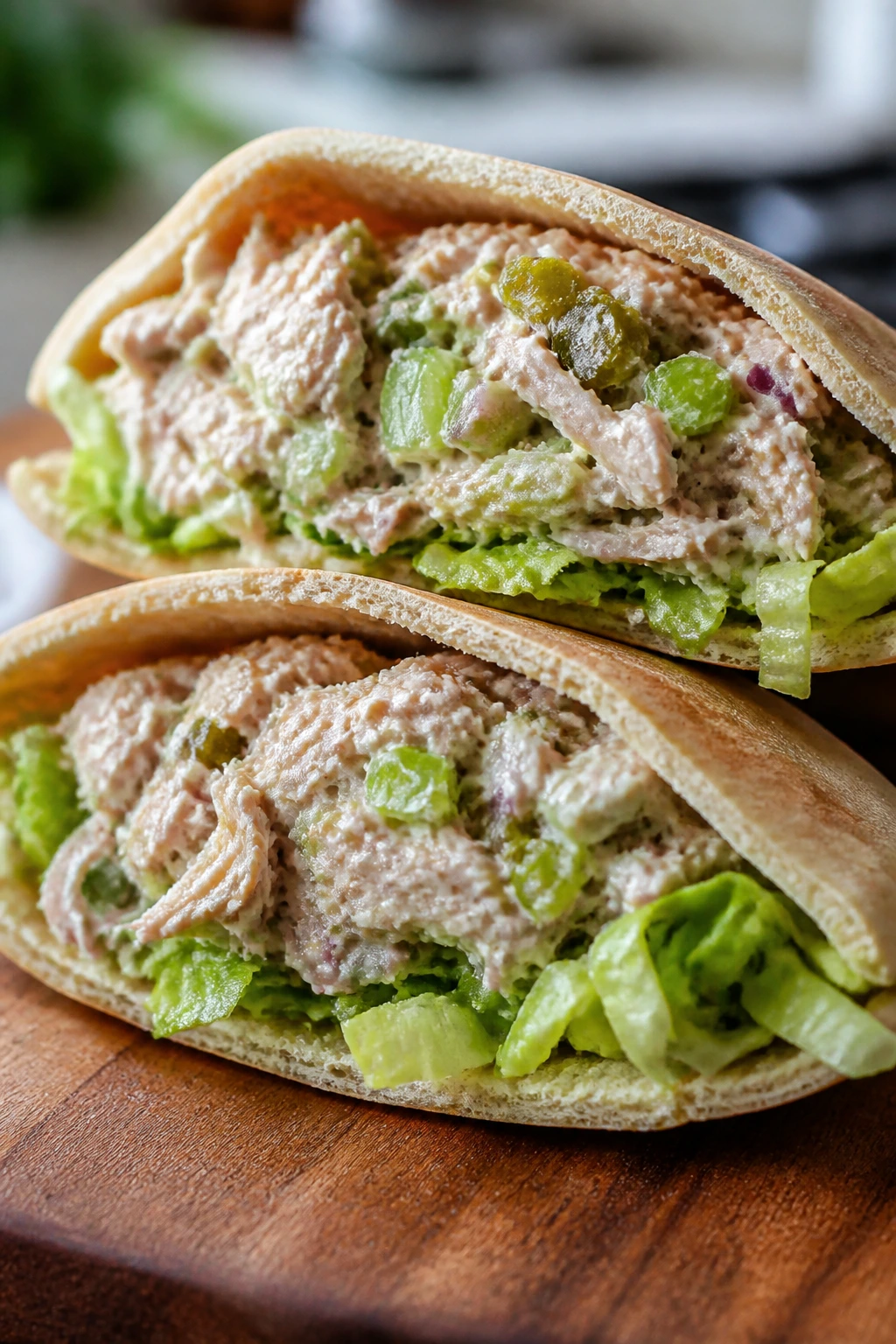 Close-up of tuna salad stuffed pita pockets on a wooden cutting board