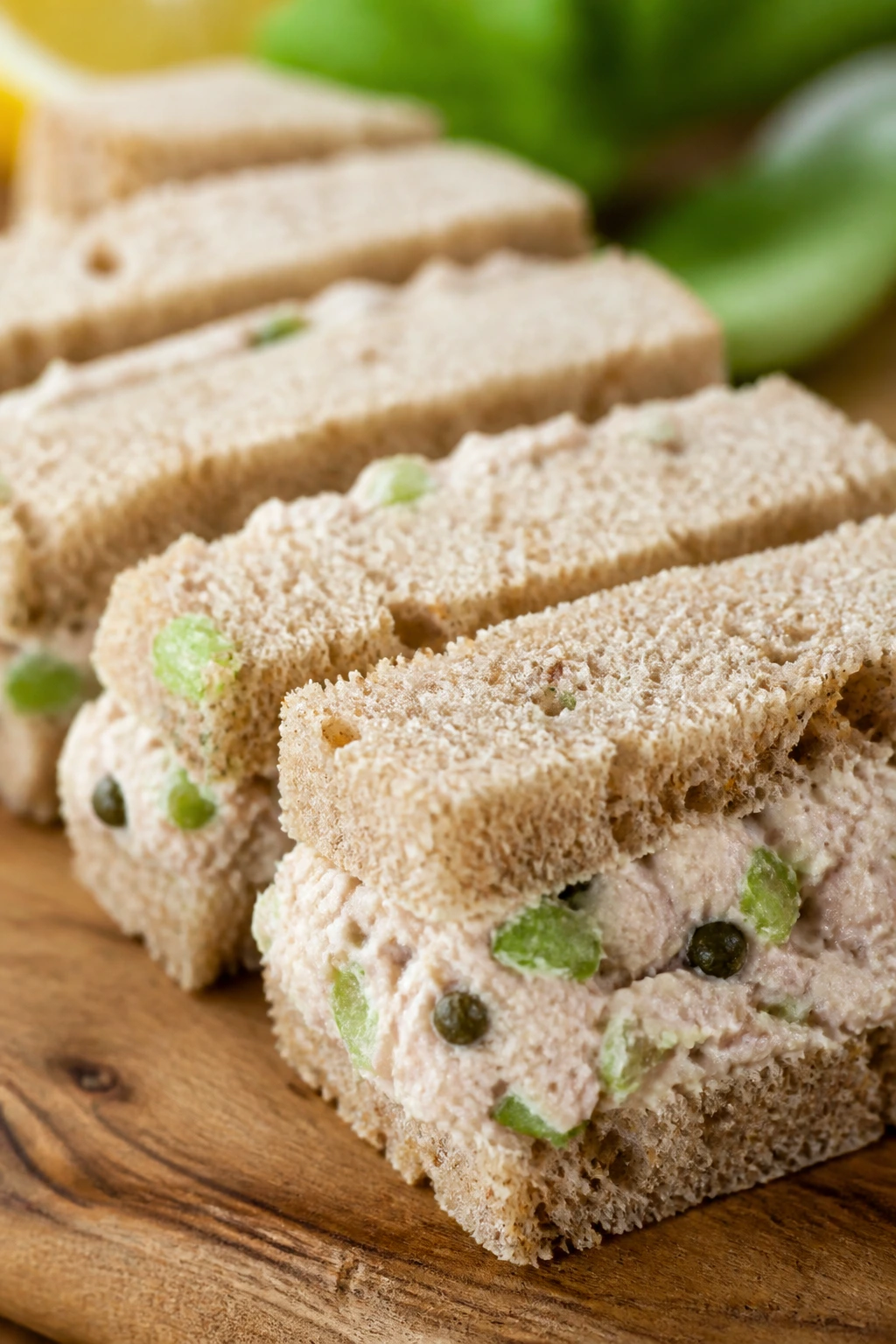 Tuna salad finger sandwiches with celery and capers on bread