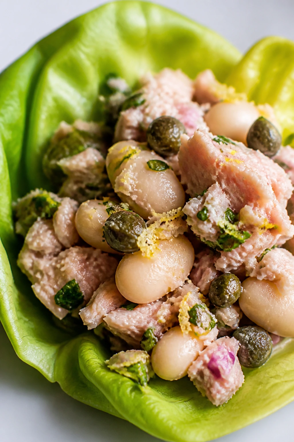 Lettuce cup filled with tuna and white beans on a clean counter