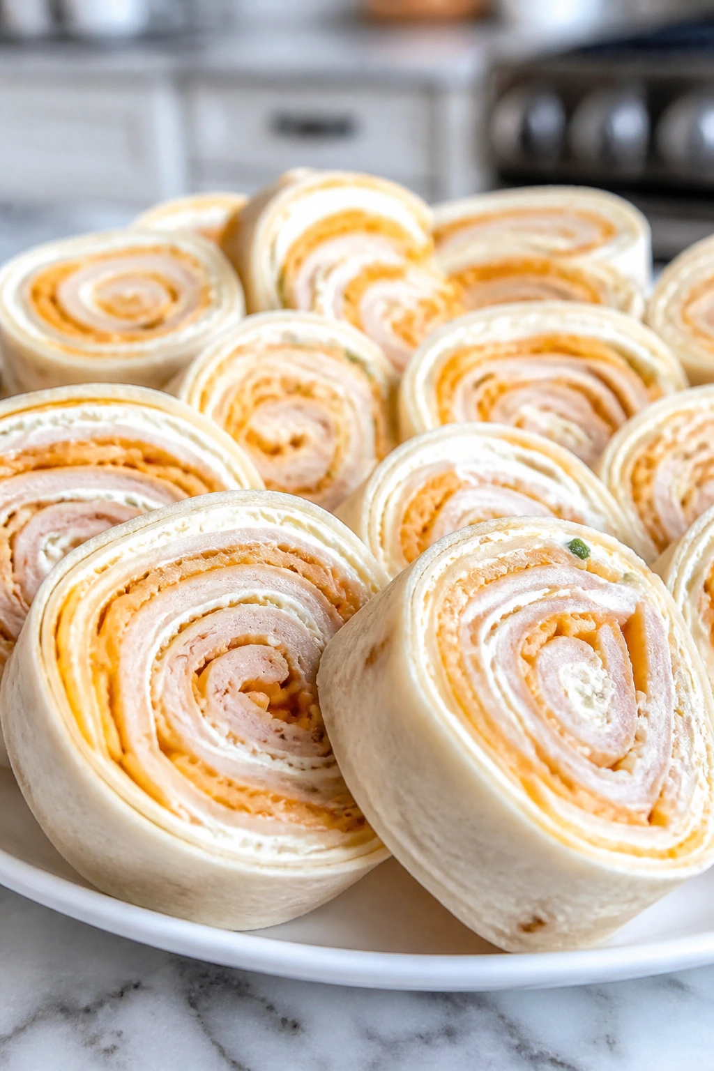 Turkey pinwheel roll-ups sliced on a white plate in a home kitchen