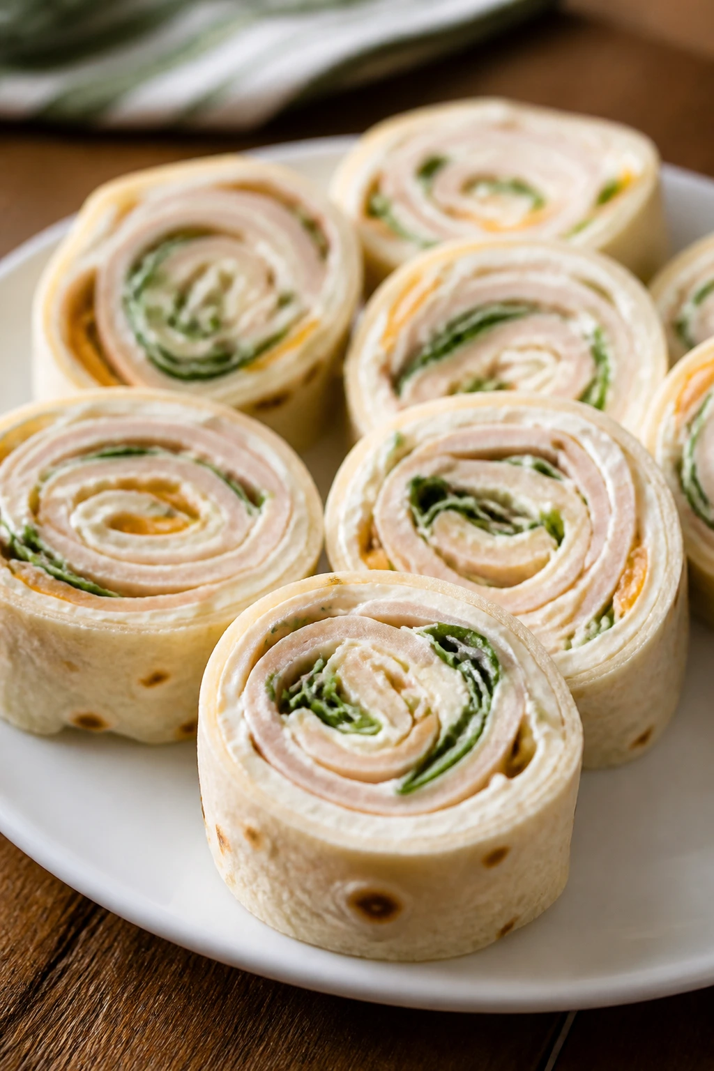 Close-up of turkey pinwheel wraps sliced to show cream cheese filling.