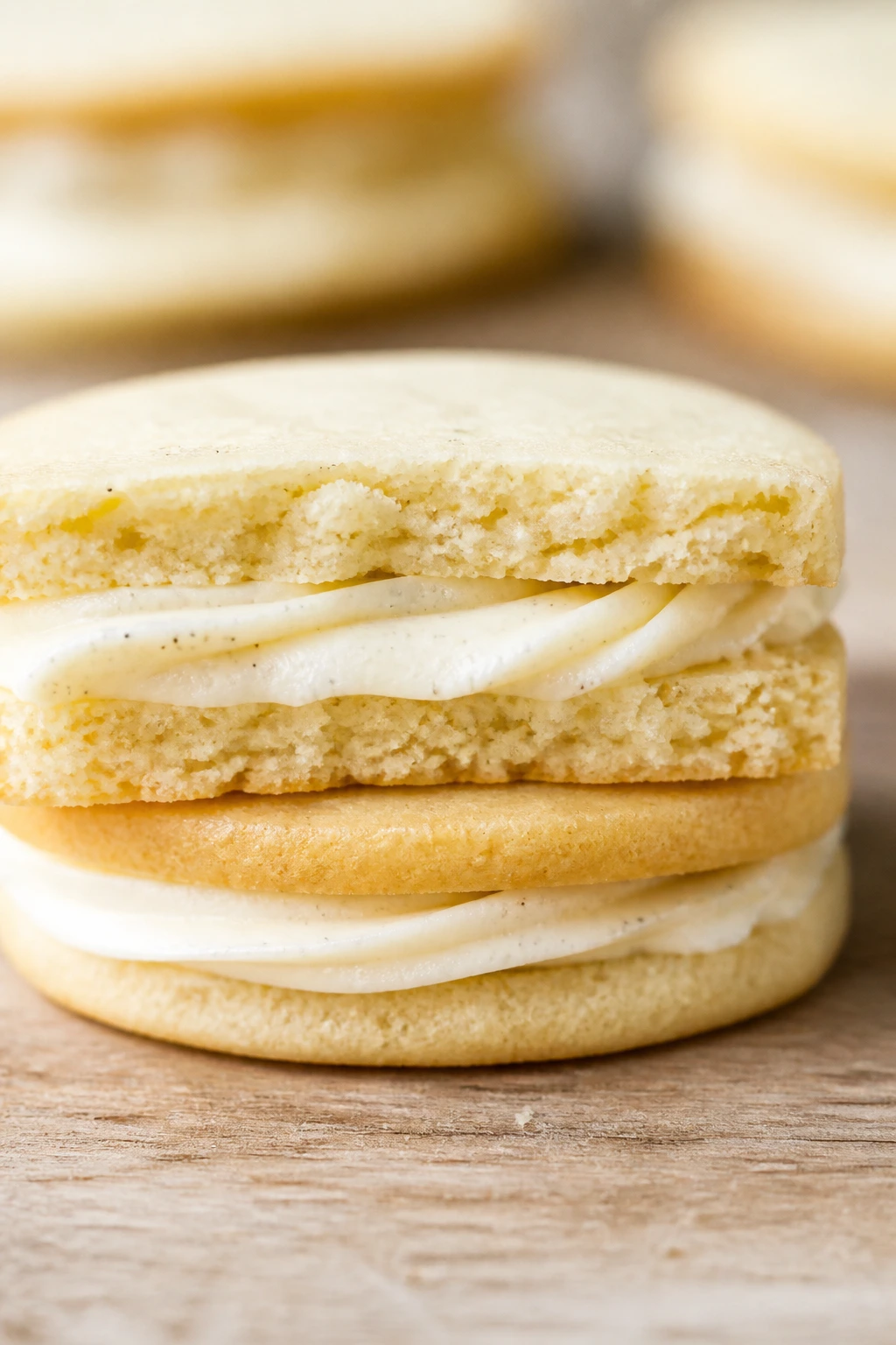 Cross-section of vanilla bean sandwich cookies showing buttercream filling