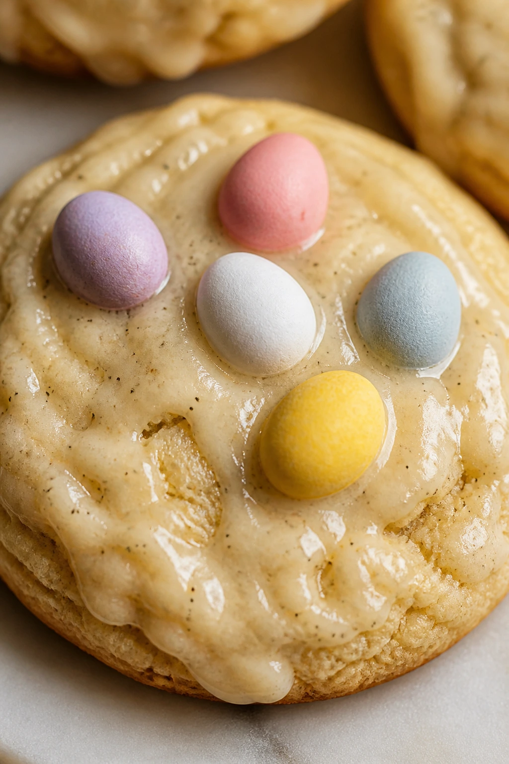 Close-up of Vanilla Bean Egg Drop Cookie with glaze and candy eggs