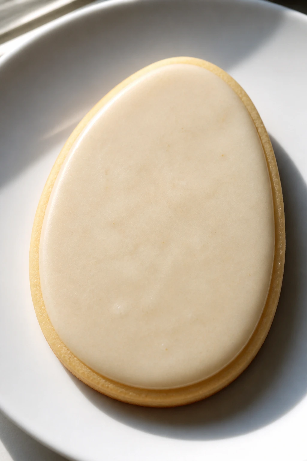 Vanilla butter Easter egg cookie with glaze on plate