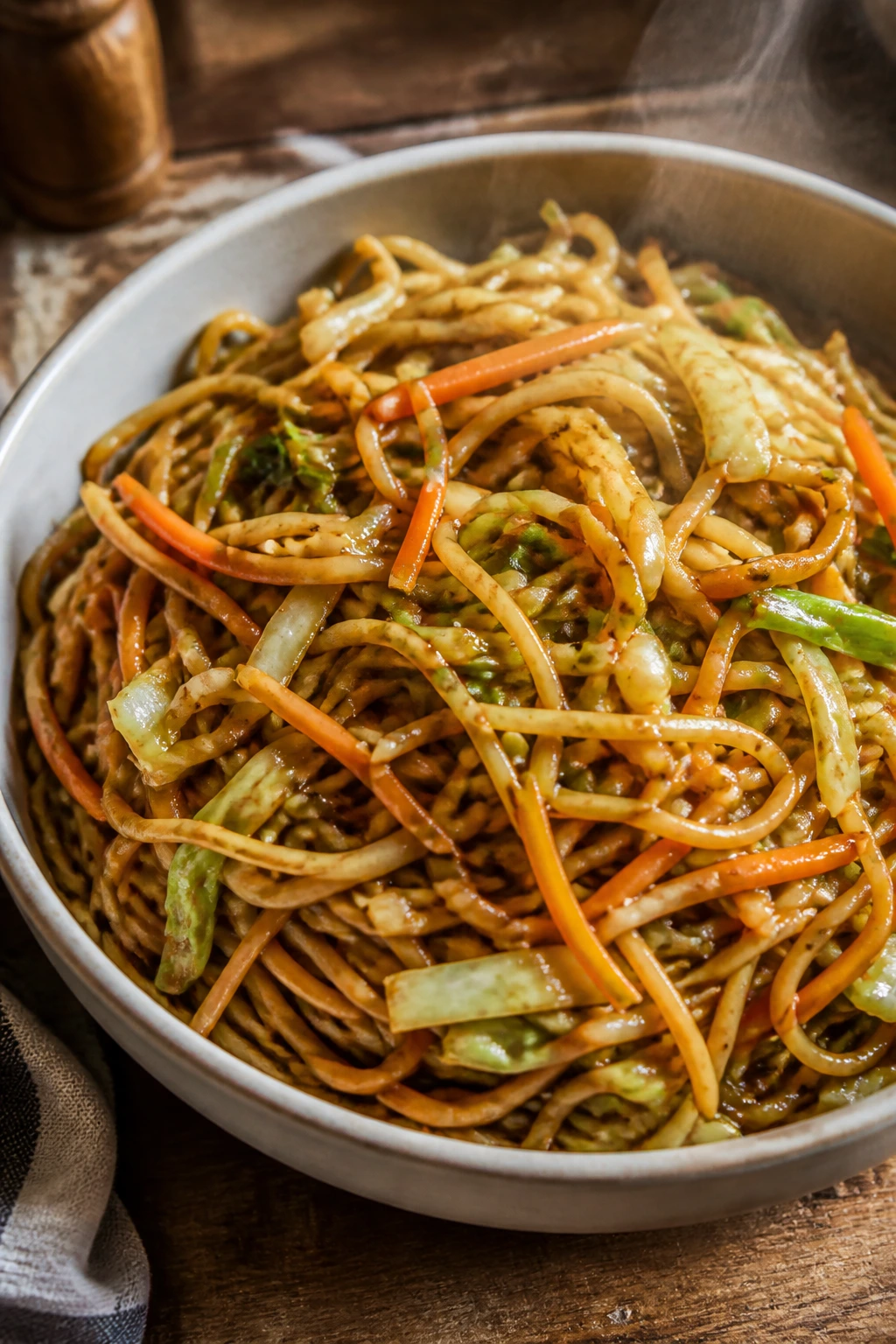 Close-up of vegetable lo mein in a bowl with cabbage and carrot pieces