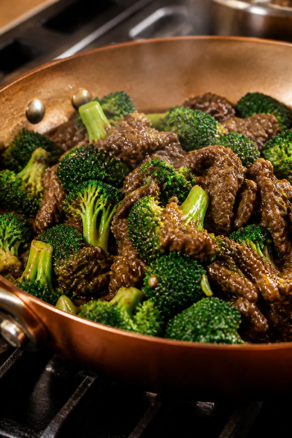 Skillet with beef and broccoli on a stove under warm light