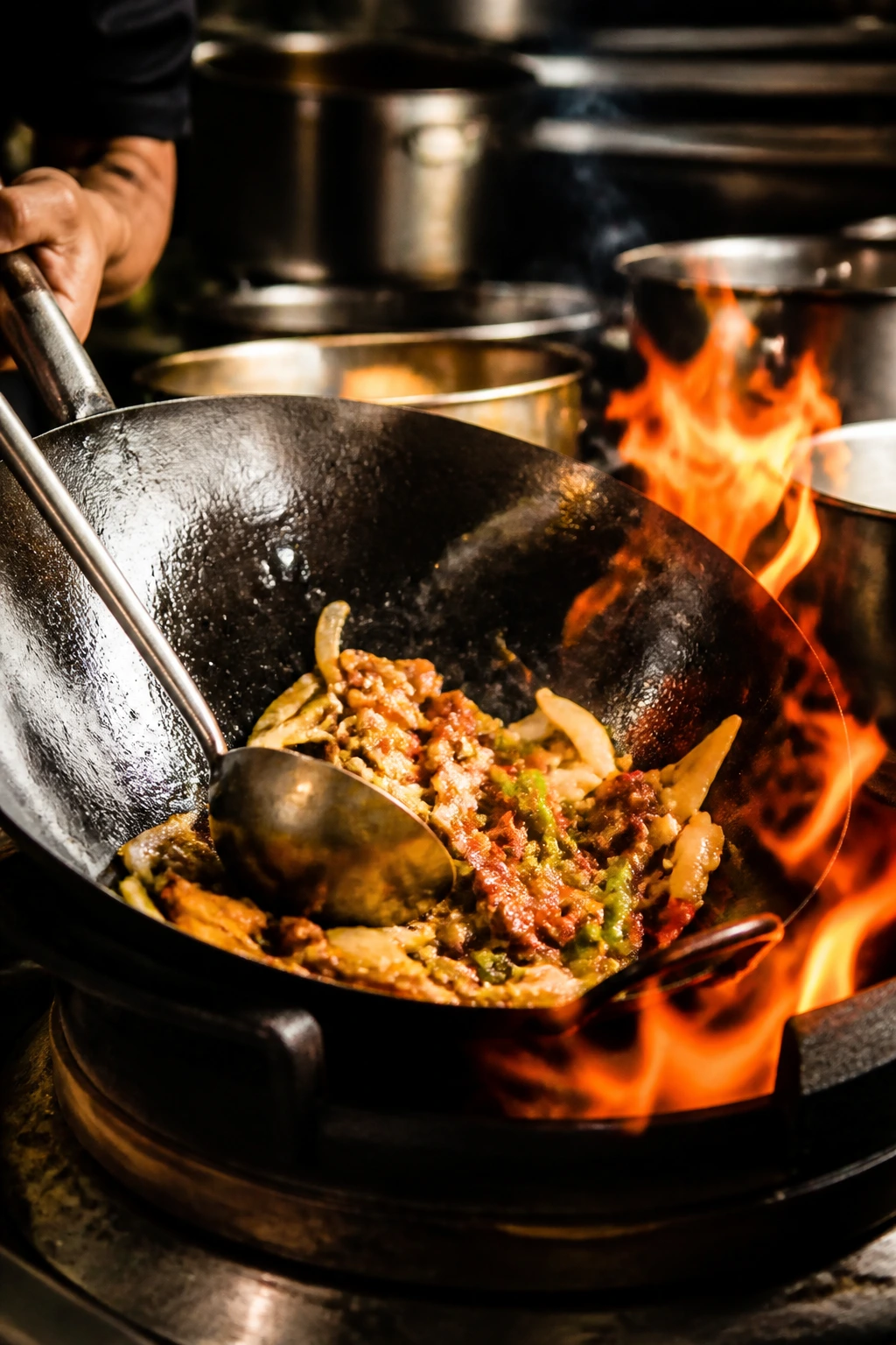 Hot wok with flames showing high-heat cooking in a professional kitchen.